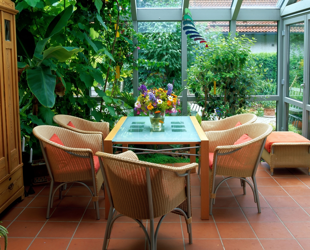Tisch, Stühle und Pflanzen im Wintergarten