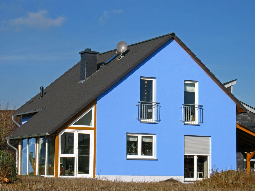 Blaues Haus mit Wintergarten in der Dachschräge