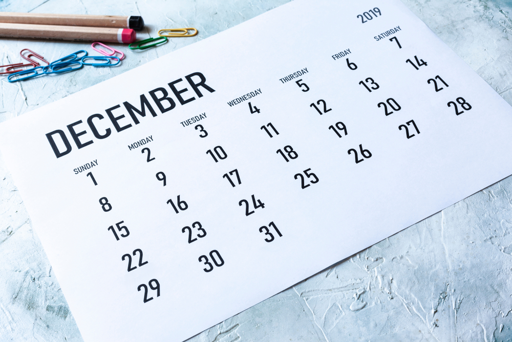 Einfaches Monatskalender 2019 auf Tisch mit Bürobedarf mit dem Monat Dezember