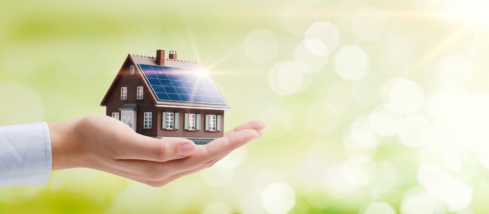 Eine Hand hält ein Energieeffizientes Haus