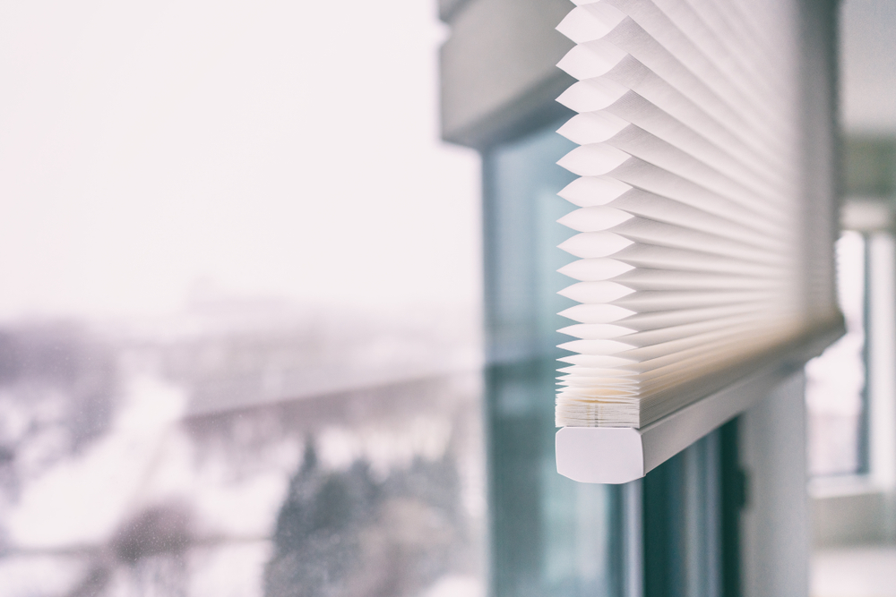 Hausblinds - schnurlose zelluläre Honigwabenkabel plissiert moderne Schattierungen auf den Fenstern der Wohnung. Die automatisierten Vorhänge sind.